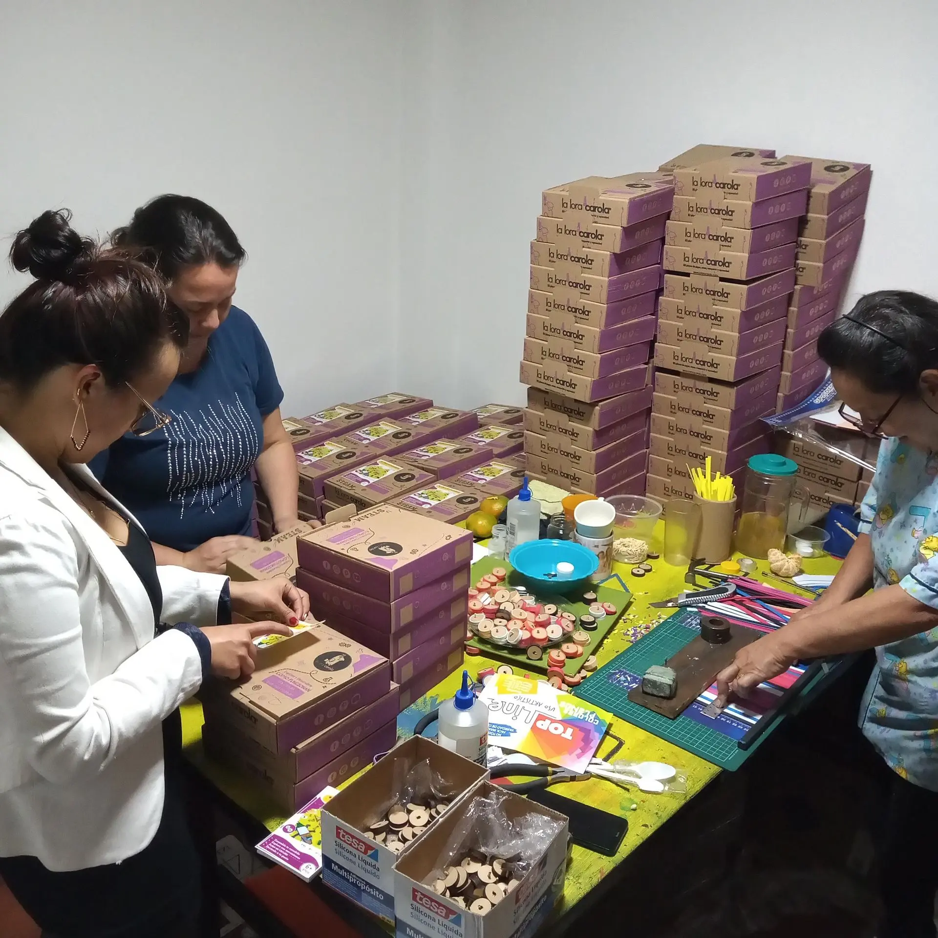 Colaboradores de La Lora Carola empacando kits didácticos